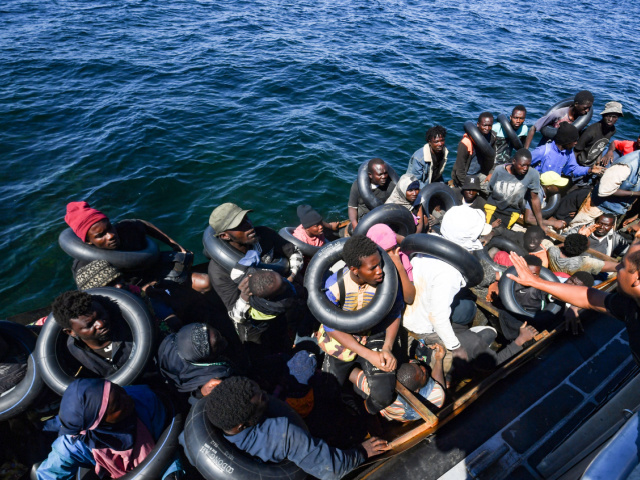 TOPSHOT - Migrants of African origin trying to flee to Europe are crammed on board of a small boat, as Tunisian coast guards prepare to transfer them onto their vessel, at sea between Tunisia and Italy, on August 10, 2023. Mediterranean Sea crossing attempts from Tunisia have multiplied following a incendiary speech by the Tunisian president who had alleged that "hordes" of irregular migrants were causing crime and posing a demographic threat to the mainly Arab country. (Photo by FETHI BELAID / AFP) (Photo by FETHI BELAID/AFP via Getty Images)