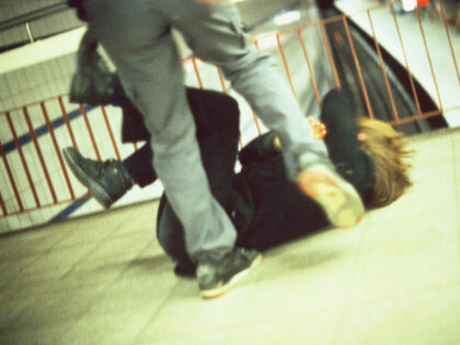 Man Kicking a Woman in Subway Station - stock photo