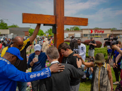 FILE - A group prays at the site of a memorial for the victims of the Buffalo supermarket shooting outside the Tops Friendly Market on Saturday, May 21, 2022, in Buffalo, N.Y. The city of Buffalo will pause Sunday to mark the passing of one year since the attack. Events …