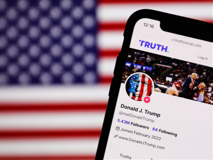 American flag displayed on a screen and Donald Trump account on Truth Social displayed on