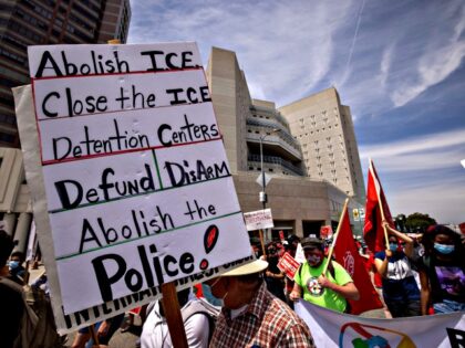People protesting ICE (US Immigration and Customs Enforcement) detention centers pass The Metropolitan Detention Center, Los Angeles, where many undocumented immigrants are held in custody, as a coalition of activist groups and labor unions in a May Day march for workers' and human rights in Los Angeles, California on May …