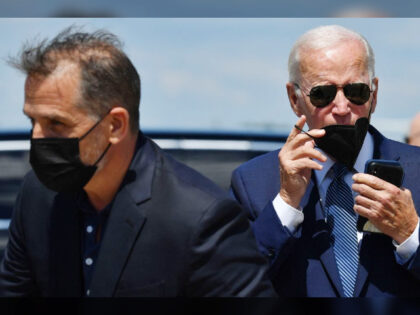 US President Joe Biden (R) and his son Hunter Biden walk to a vehicle after disembarking A