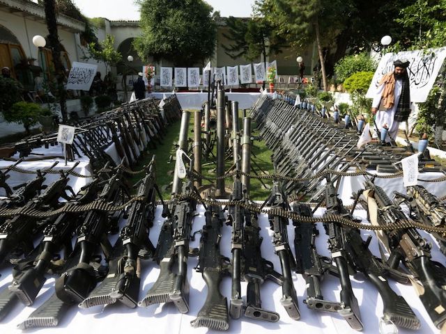 Taliban fighters stand guard next to the weapons on display for media representatives after an operation in which weapons and ammunition were seized from various locations in Asadabad of Kunar Province on September 25, 2022. (Photo by AFP) (Photo by -/AFP via Getty Images)