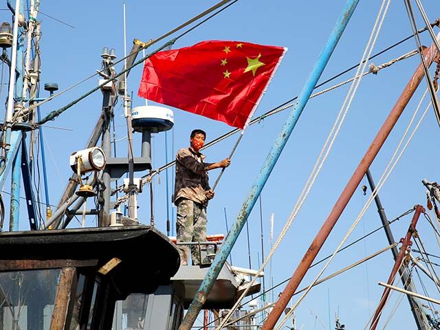 Fishermen hang brand new five-star red flags on their fishing boats in Lianyungang, Jiangs