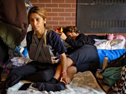 Norkys Amaro, a recent arrival from Venezuela, with her son, Yokender, 14, on the floor where they are staying with other migrants, May 22, 2023, at the 7th District police station in Englewood, in Chicago. (Brian Cassella/Chicago Tribune/Tribune News Service via Getty Images)