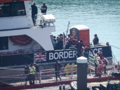 Migrants are escorted ashore from a UK Border Force vessel in Dover, southeast England, on