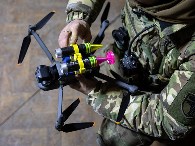A drone operator with the Ukrainian Army's 93rd Brigade attaches grenades to a DJI Ma