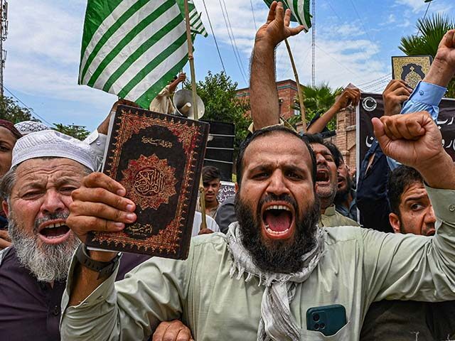 A man holding a copy of the Koran shouts slogans during a demonstration in Peshawar on Jul