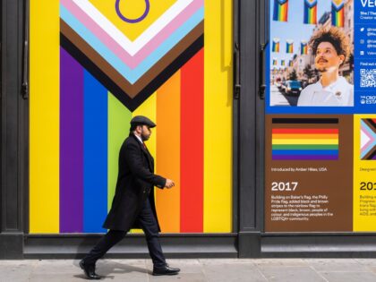 People pass an Intersex-inclusive Progress Pride flag in an empty shop window on 9th July 2023 in London, United Kingdom. The flag includes the rainbow flag stripes to represent LGBTQ+ communities, with colours from the Transgender Pride Flag and to also represent people of colour. (photo by Mike Kemp/In Pictures …