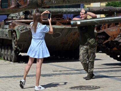 A Ukrainian serviceman gives a thumbs as he poses for a photograph next to a tank during an open-air exhibition of destroyed Russian military vehicles at Mykhaylo Square in Kyiv, on August 3, 2023, amid the Russian invasion of Ukraine. (Photo by Sergei SUPINSKY / AFP) (Photo by SERGEI SUPINSKY/AFP …