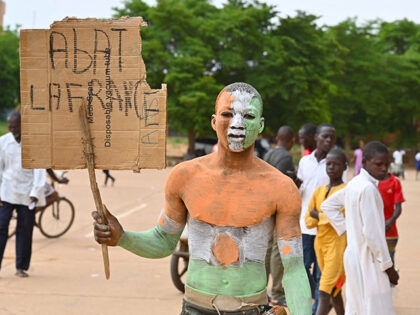 A supporter of Niger's National Council for the Safeguard of the Homeland (CNSP) whose body is painted with the colours of the Niger flag demonstrates in Niamey on August 6, 2023. Thousands of supporters of the military coup in Niger gathered at a Niamey stadium Sunday, when a deadline set …
