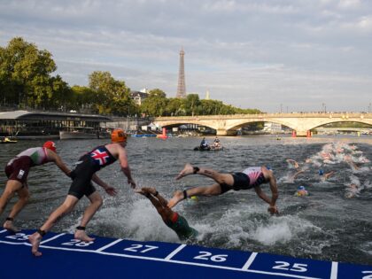 Triathlon athletes dive in the Seine river with The Eiffel Tower in the background during