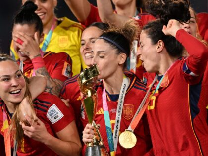 Spain's forward #09 Esther Gonzalez kisses the trophy as Spain's players celebrate on the