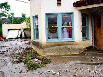 Residents trapped in their home peer out a window while waiting for help in Yucaipa, California on August, 21, 2023. Tropical Storm Hilary drenched Southern California with record rainfall, shutting down schools, roads and businesses before edging in on Nevada on August 21, 2023. California Governor Gavin Newsom had declared …