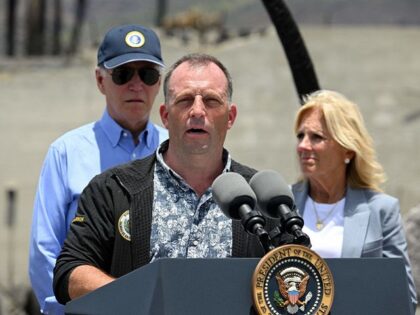Hawaii Governor Josh Green (C) delivers remarks as US President Joe Biden listens during a visit to an area devastated by wildfires in Lahaina, Hawaii on August 21, 2023. The Bidens are expected to meet with first responders, survivors, and local officials following deadly wildfires in Maui. (Photo by Mandel …