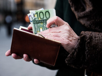 A customer places euro banknotes into a purse ahead of the 171st Organization of Petroleum