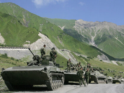 A convoy of Russian troops makes its way through the mountains toward the armed conflict b
