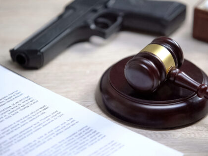 Gun on table, gavel lying on sound block, illegal use weapon, court hearing