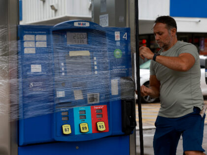 CLEARWATER BEACH, FLORIDA - AUGUST 29: Nazih Tageddine wraps cellophane around his gas pump to prevent it from being damaged by the rain from Hurricane Idalia as it passes offshore on August 29, 2023 in Clearwater Beach, Florida. Hurricane Idalia is forecast to make landfall on the Gulf Coast of …