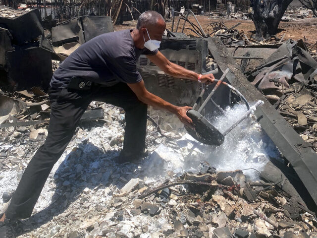 Anthony M. La Puente, 44, recovers items from his house in the aftermath of a wildfire in