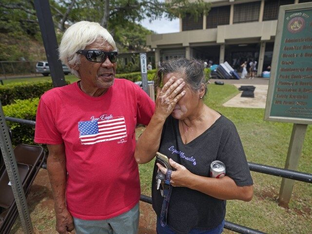 Myrna and Abraham Ah Hee react as they stand in front of an evacuation center at the War Memorial Gymnasium, Thursday, Aug. 10, 2023, in Wailuku, Hawaii. The Ah Hees were there because they were looking for Abraham's brother. Their own home in Lahaina was spared, but the homes of …