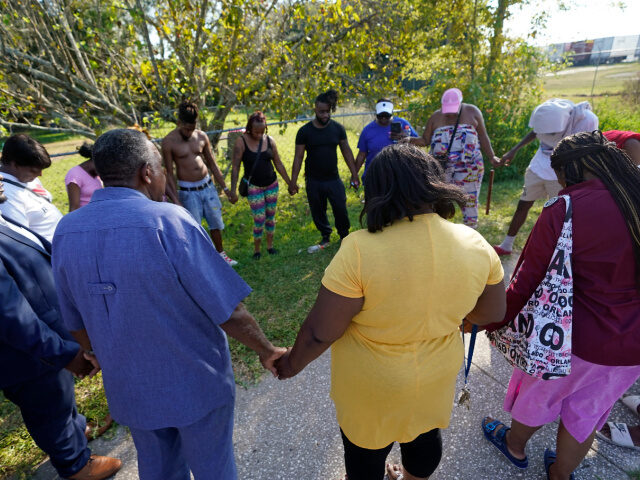 Residents gather for a prayer near the scene of a mass shooting at a Dollar General store,