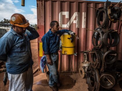 Heavy machinery workers for Venezuela's iron ore producer, CVG Ferrominera Orinoco, take a break at the base of Bolivar Hill, a mine outside of Ciudad Piar, Venezuela, on Thursday, July 9, 2015. Photographer: Meridith Kohut/Bloomberg via Getty Images