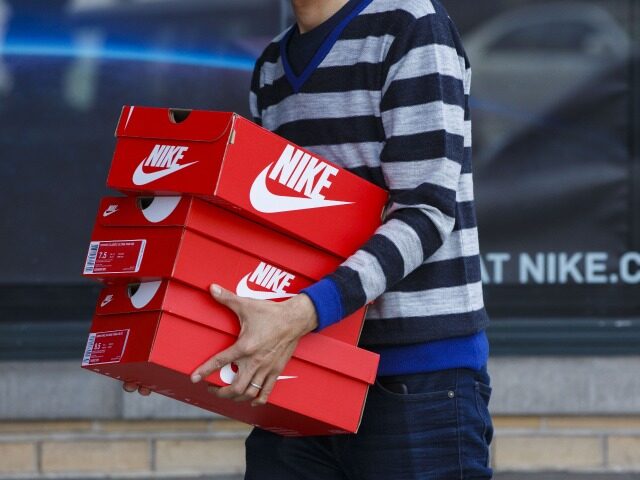 A customer carries boxes of Nike Inc. shoes outside of the NikeTown Los Angeles retail sto