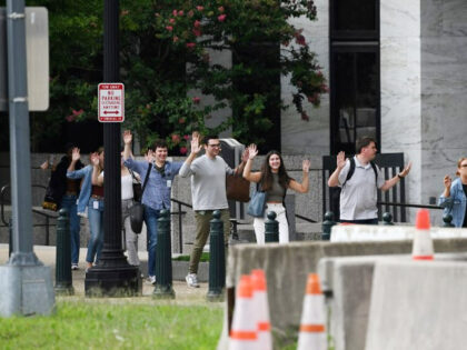 People walk out of the Russell Senate Office Building with their hands in the air in Washi