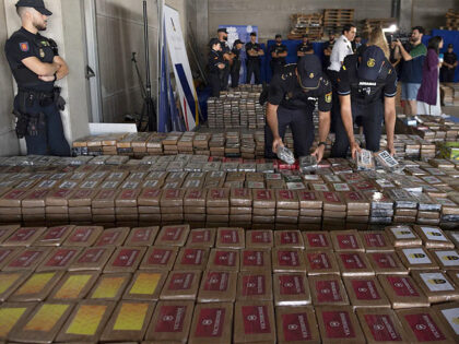 TOPSHOT - Spanish National Police and Customs officers hold some packages of cocaine total