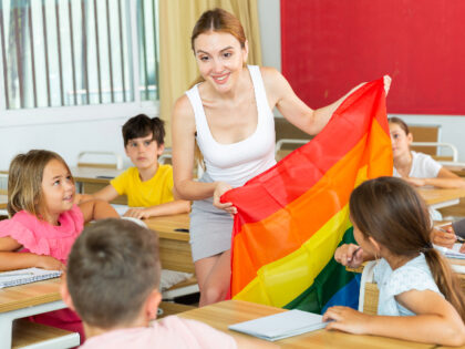 Young progressive female teacher discussing with preteen children about LGBT social moveme