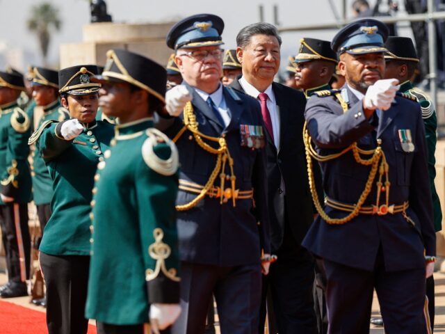 Chinese President Xi Jinping (C) inspects the guard of honour during his state visit to So