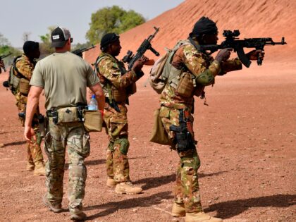 A US army instructor walks next to Malian soldiers on April 12, 2018 during an anti-terrorism exercise at the Kamboinse - General Bila Zagre military camp near Ouagadougo in Burkina Faso. Some 1,500 African, American and European troops began maneuvers in Burkina Faso, western and northern Niger on April 12 …