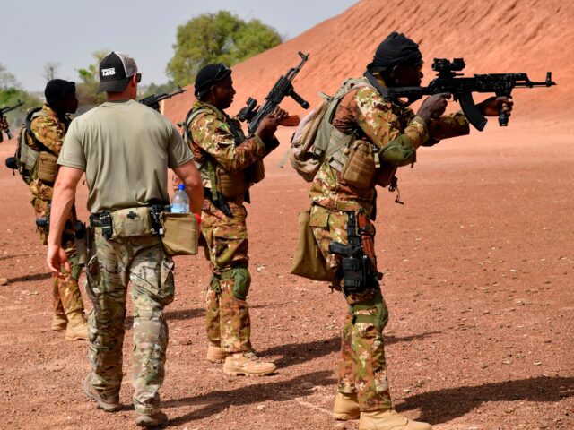 A US army instructor walks next to Malian soldiers on April 12, 2018 during an anti-terror