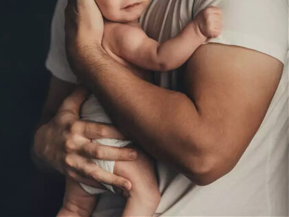 Father holds a baby in his arms - stock photo