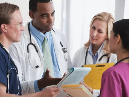 Doctors reviewing medical chart - stock photo doctor / nurse / hospital