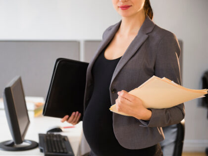Pregnant Caucasian businesswoman working in office - stock photo