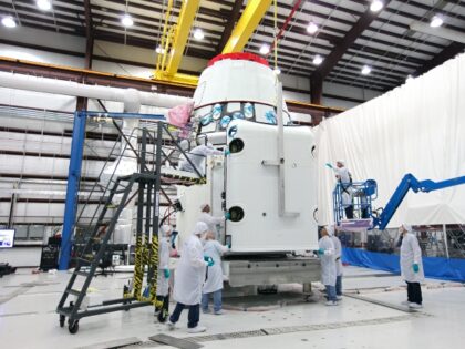 Workers guide a solar array fairing into place inside the processing hangar used by Space Exploration Technologies, or SpaceX, at Cape Canaveral Air Force Station, Fla ca. 2013. (Photo by: HUM Images/Universal Images Group via Getty Images)