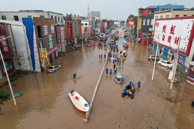 This aerial view shows rescue teams working in a flooded village after heavy rains in Zhuo