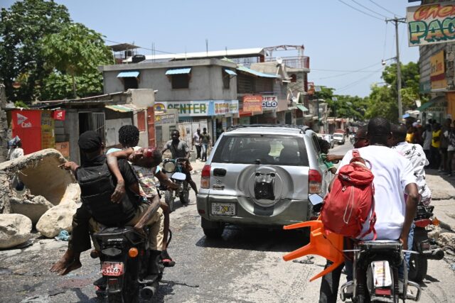 An injured man is transported on a motorcycle to hospital after being shot during gang vi