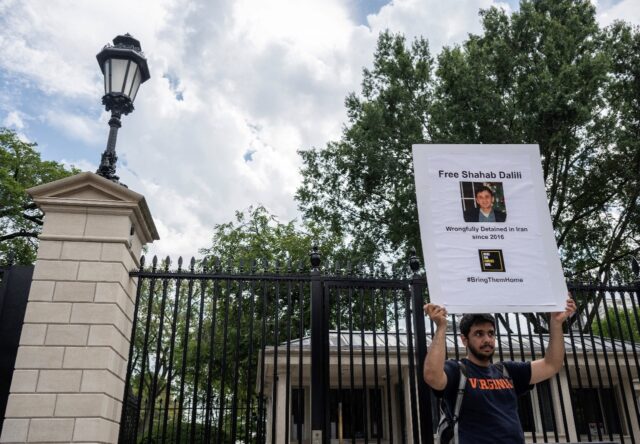 Darian Dalili holds up a sign as he holds a hunger strike outside the White House to call