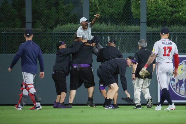 A fan yells to Atlanta Braves star Ronald Acuna after running onto the field and being app