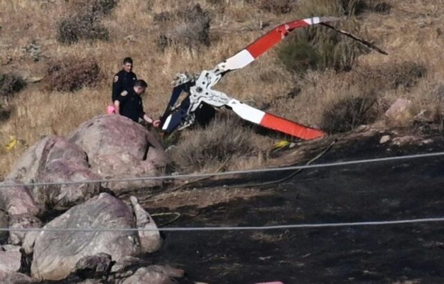 Investigators study rotor blades from a firefighting helicopter that crashed after collidi