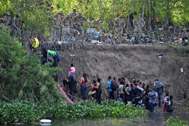Migrants who crossed the Rio Bravo river (Rio Grande in the US) are stopped by members of