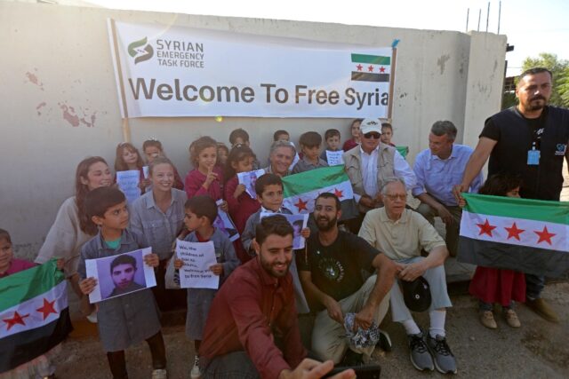 The members of Congress pose with orphaned children at a hospital in Syria's border town o