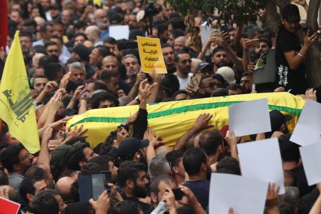 People carry the body of a fighter of the Lebanese Hezbollah movement during his funeral a