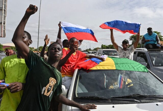 Supporters of Niger's military takeover wave Russian flags as they demonstrate in Niamey