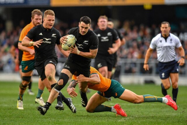 New Zealand's Will Jordan (C) is tackled by Australia's Quade Cooper (R) during the Rugby