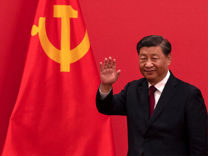 Xi Jinping waves as he leaves after speaking at a press event with members of the new Stan