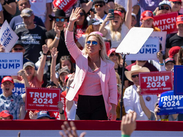 US Republican Representative Marjorie Taylor Greene, from Georgia, waves as former US President Donald Trump mentions her during a 2024 election campaign rally in Waco, Texas, March 25, 2023. - Trump held the rally at the site of the deadly 1993 standoff between an anti-government cult and federal agents. (Photo …